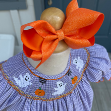 Load image into Gallery viewer, Child's dress with Halloween-themed embroidery on a smocked drerss with an orange bow.