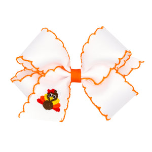 Large white bow with orange trim featuring a small turkey design on a white background