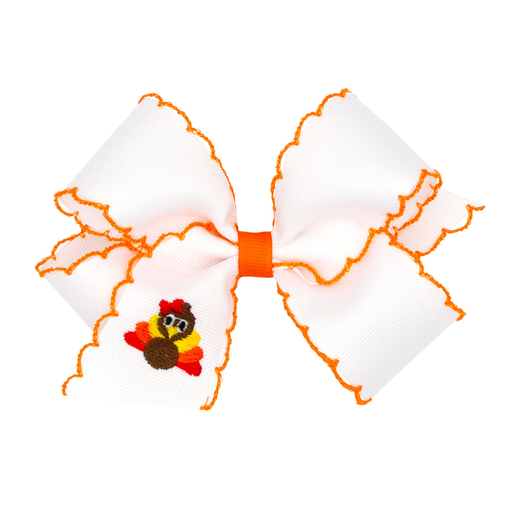 Large white bow with orange trim featuring a small turkey design on a white background