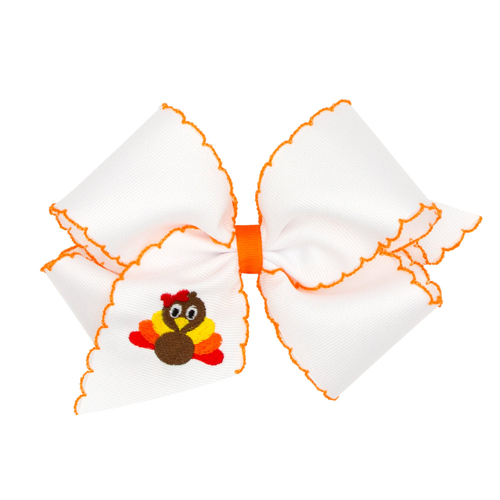 Large white bow with orange trim featuring a small embroidered turkey on a white background